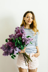 Girl with a bouquet of lilac on a white background