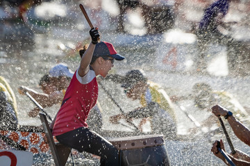 dragon boat drummer racing through spray