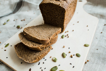 fresh sliced bread on a wooden board on a grey cloth