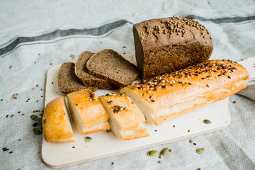 fresh sliced bread on a wooden board on a grey cloth