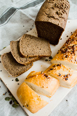 fresh sliced bread on a wooden board on a grey cloth