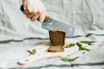 cutting with a knife freshly baked bread on a wooden Board