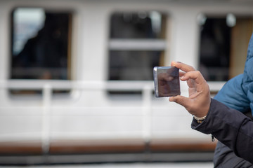 Man holding phone in hand and photographing the view. You have a sphere on your arm.