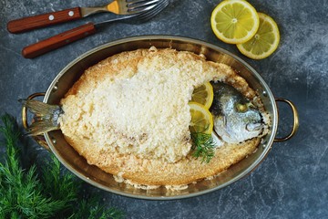 Sea fish, dorado fish baked in coarse salt mixed with egg white. Healthy food. Top view.