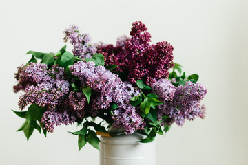 Purple bouquet of lilac flowers in a stylish vase on a white background