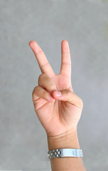 hand sign 'victory' on a grey background