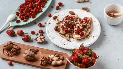 Healthy vegan breakfast concept. butter sandwich with strawberry, few pieces of toasted bread. White table background. Top view, close up, copy space, flat lay