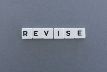 Revise word made of square letter word on grey background.