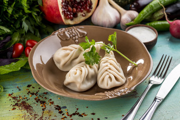 fresh boiled dumplings and fresh vegetables on blue wooden table