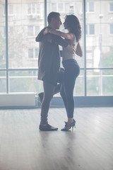 Beautiful couple dancing kizomba in dance studio