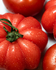 Tomate Sorte Ochsenherz frisch und reif mit Wassertropfen im Hochformat als Nahaufnahme
