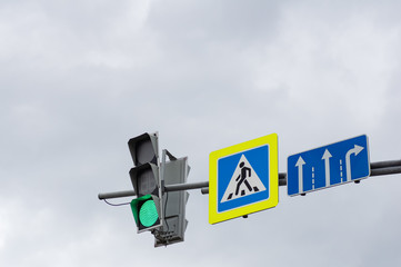 Green color on the traffic light. Sign of a pedestrian crossing.