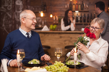 Senior man giving a bouquet of flowers to his wife