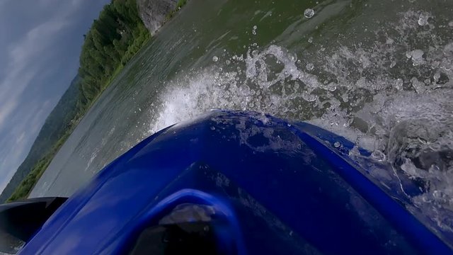 the jet ski cuts the wave turning on the river in the mountains. feed water bike close-up. super slow motion video. beautiful splashes and squall of water on the bow of the boat. stock video footage