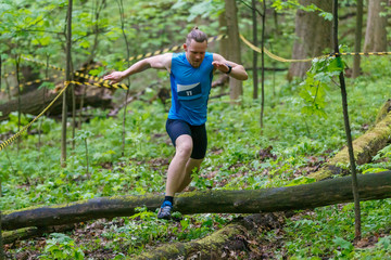 Naklejka na ściany i meble Young sporty man running trail cross in the forest