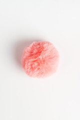 Coral fluffy fur ball on white background