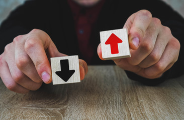 two wooden cubes in the hands of a man of red and black, red means growth and development, and...