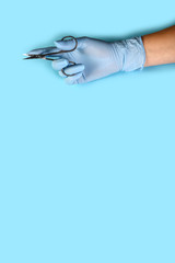 Manicure tool in the hands of the master. set of manicure accessories on blue background top view. flat lay composition with copy space