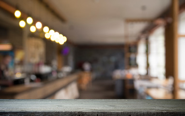 image of wooden table in front of abstract blurred background of resturant lights