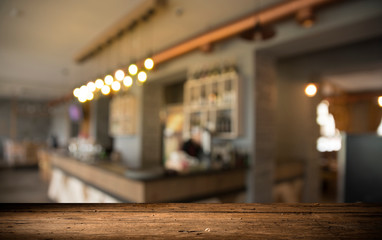 image of wooden table in front of abstract blurred background of resturant lights