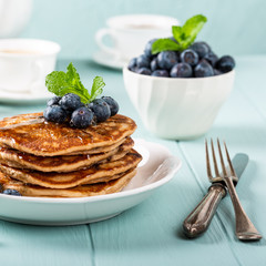 Delicious pancakes with chocolate drops, honey and blueberries. Healthy breakfast concept.