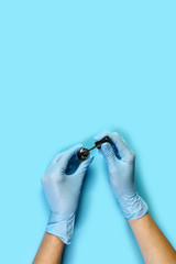 Manicure tool in the hands of the master brush with varnish. set of manicure accessories on blue background top view. flat lay composition with copy space