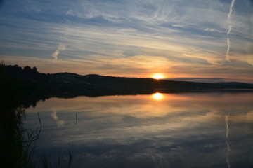 Fototapeta na wymiar symmetrical reflection in the evening on the lake