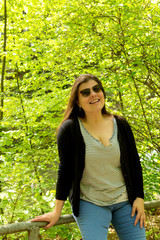 Lady poses smiling for a portrait while in a park during spring time