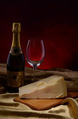 Red wine, assorted cheeses, bread and grapes in a still life setup
