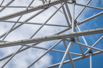 Abstract image of white steel struts and supports in front of a white-blue sky