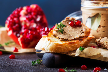 Meat liver pate on toasted bread with fruit seeds and spice herb, brown kitchen table, copy space, selective focus