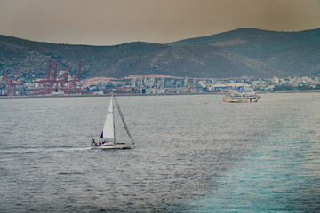 Athens Peiraeus /Greece 22 april 2019 :snapshot from the boat it has just left the port and the capital,passing by other ships transportaion and industrial,and the gas and polluted sky of the city
