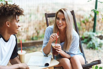 Happy tennage couple spending time at the cafe