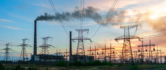 high-voltage lines against the background of electrical distribution stations at sunrise.