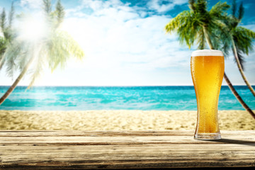 Summer background of wooden desk and cold beer. Free space for your decoration. Beach landscape...