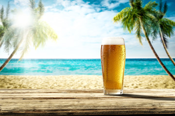 Summer background of wooden desk and cold beer. Free space for your decoration. Beach landscape...