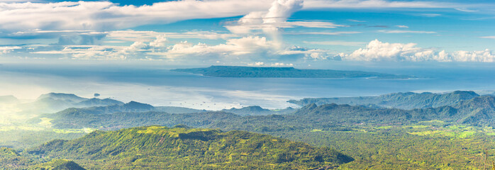 Panoramic view from a high green hill to the sea, islands, rice terraces, fields and forests in indonesia, Agung volcano slope