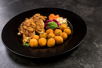 Fried chicken with potato balls and salad, restaurant serving portion