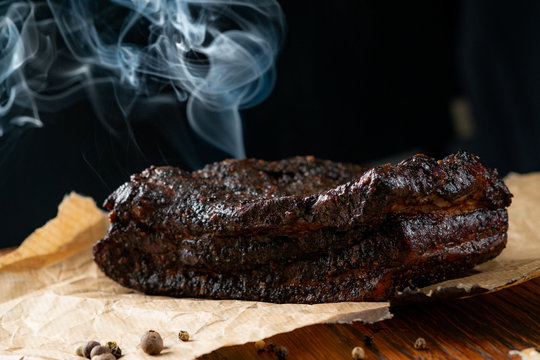 Smoked Beef Brisket BBQ with a dark bark on a wooden board