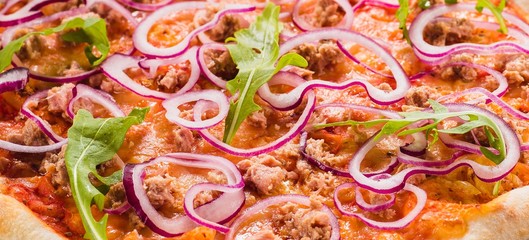 Italian pizza with chicken, onions and rucola leaves on a dark wooden background with ingredients around (close)