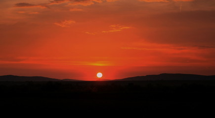 Fototapeta na wymiar the sun sets over a hill