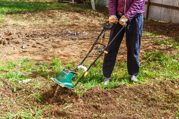 Man plows the earth with a cultivator