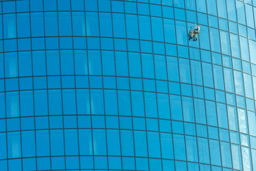 Industrial climber washes office building glasses