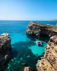 Obraz premium Lagoon with light blue water near island. Nature summer seascape in Malta. Travel and leisure in summer concept