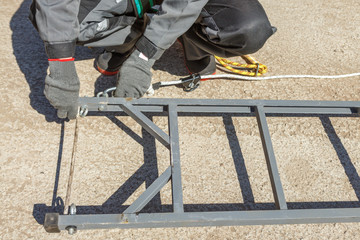 Worker electrician fastened by a safety belt