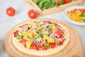 Raw pizza dough with tomato sauce, ingredients