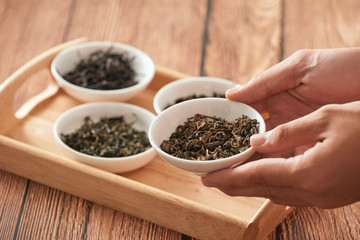 Dry tea leaves on the plate in the human hand