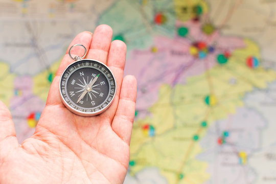 compass in hand on a background map - Powered by Adobe