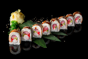 Sushi roll (Maguro) with tuna, shrimp, salmon, smoked eel, avocado, philadelphia cheese on black background. Sushi menu. Japanese food.