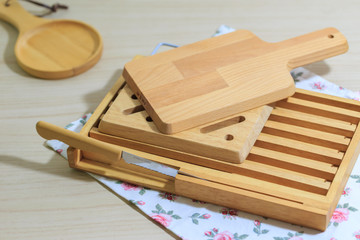 Kitchenware collecttion set, Vintage cutting wood board and tray with bread knife lie on cloth napkin and wooden table background